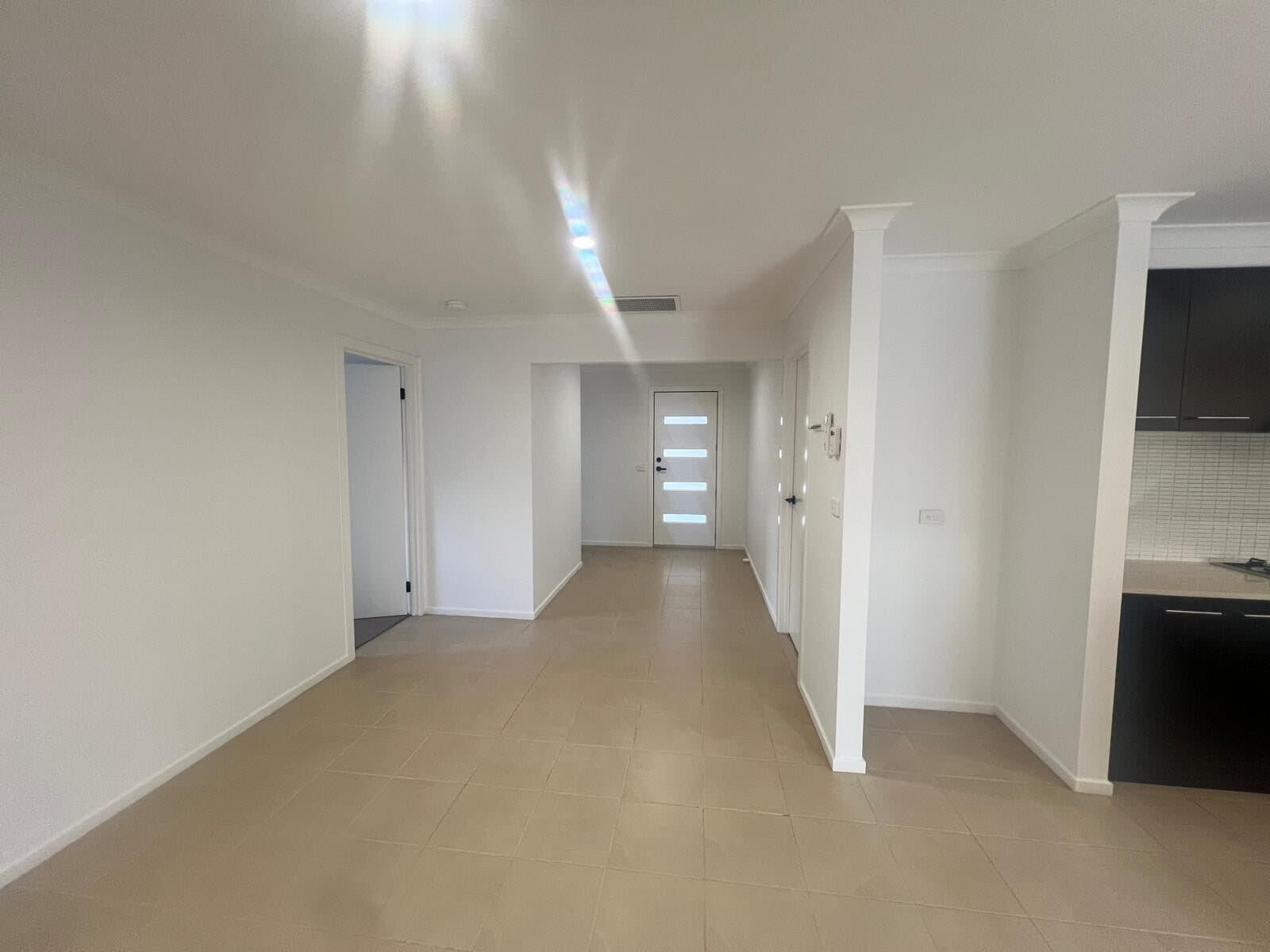 Entry hallway repainted white with clean skirting and door frames