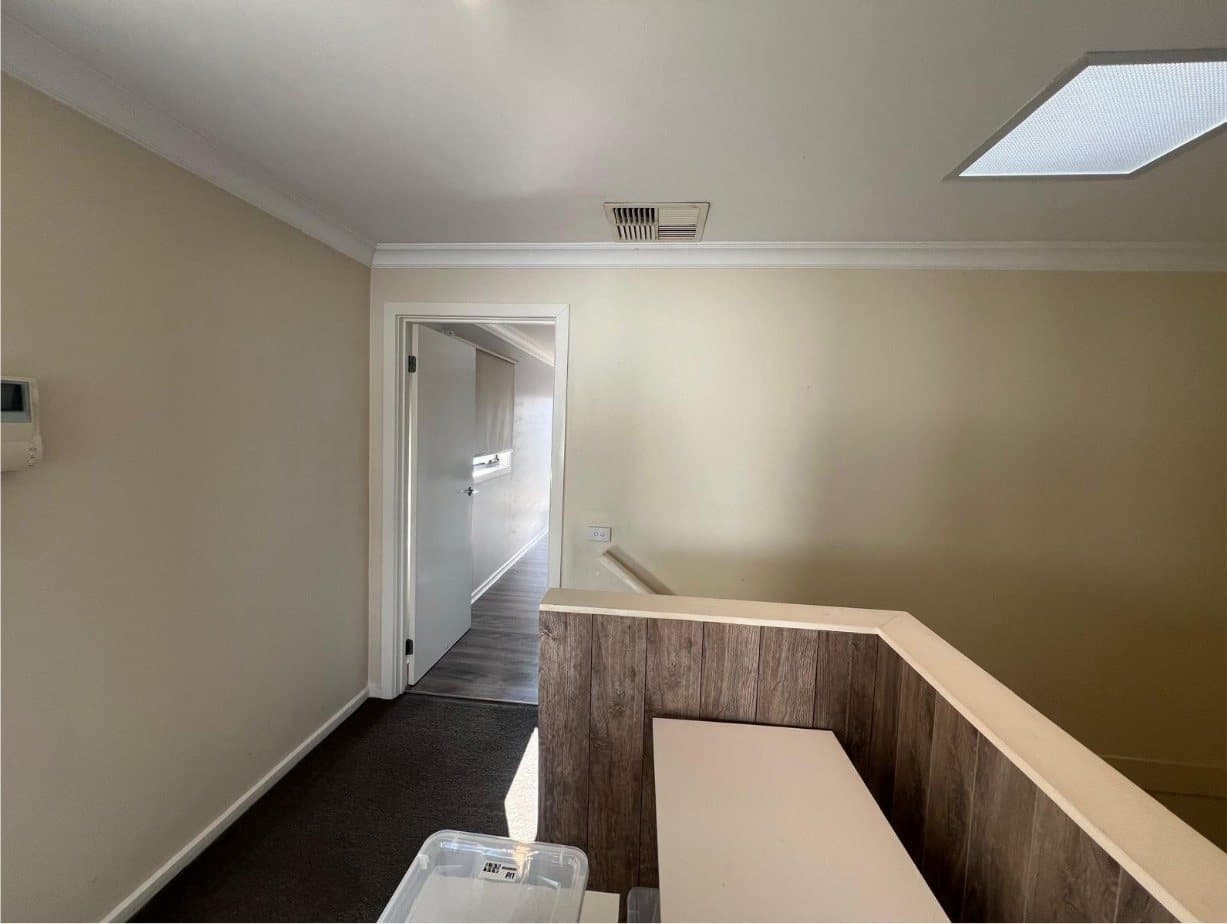 Upstairs landing with tired beige walls before repainting