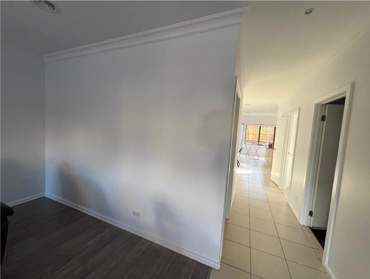 Hallway after repainting, bright white walls and crisp cornice line
