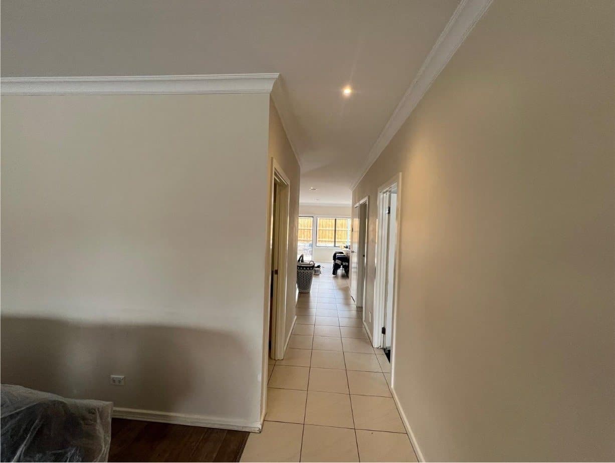 Long hallway with dated beige walls before painting